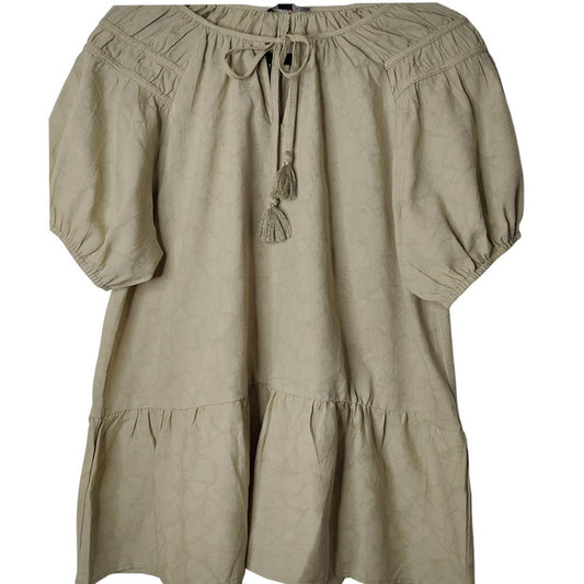 A beige jacquard woven blouse with a shirring detail and tassel tie.