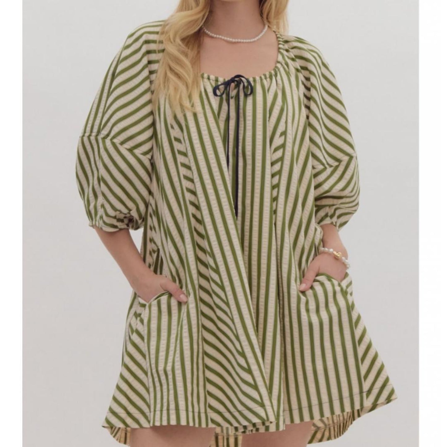 A striped half sleeve drop shoulder mini dress in olive green with a tie at the neckline and pockets at the side.