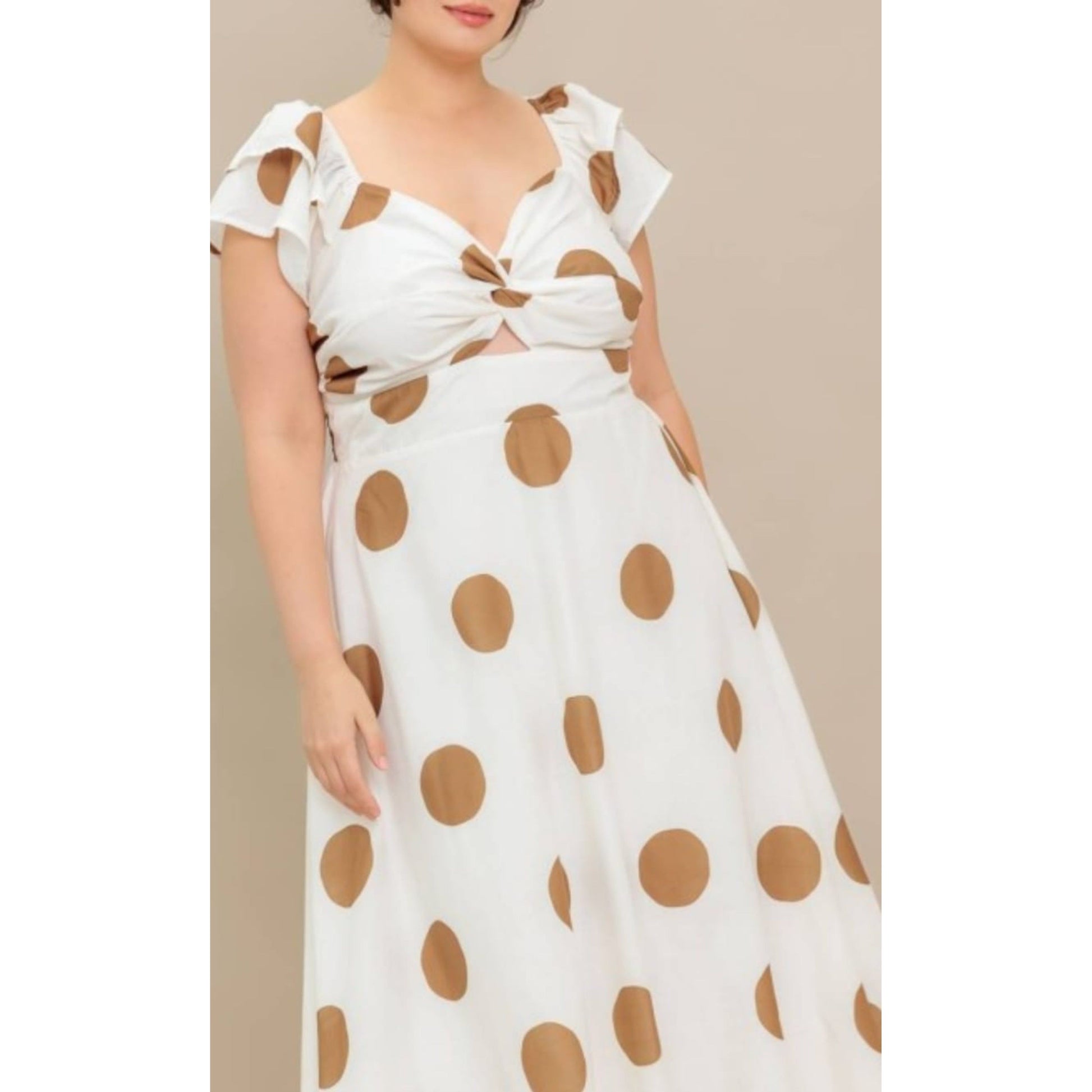 White dress with brown polka dots on a beige background