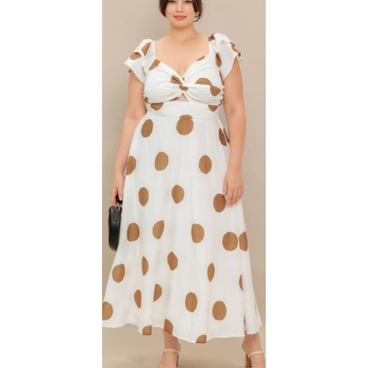 Woman wearing a white dress with brown polka dots against a beige background