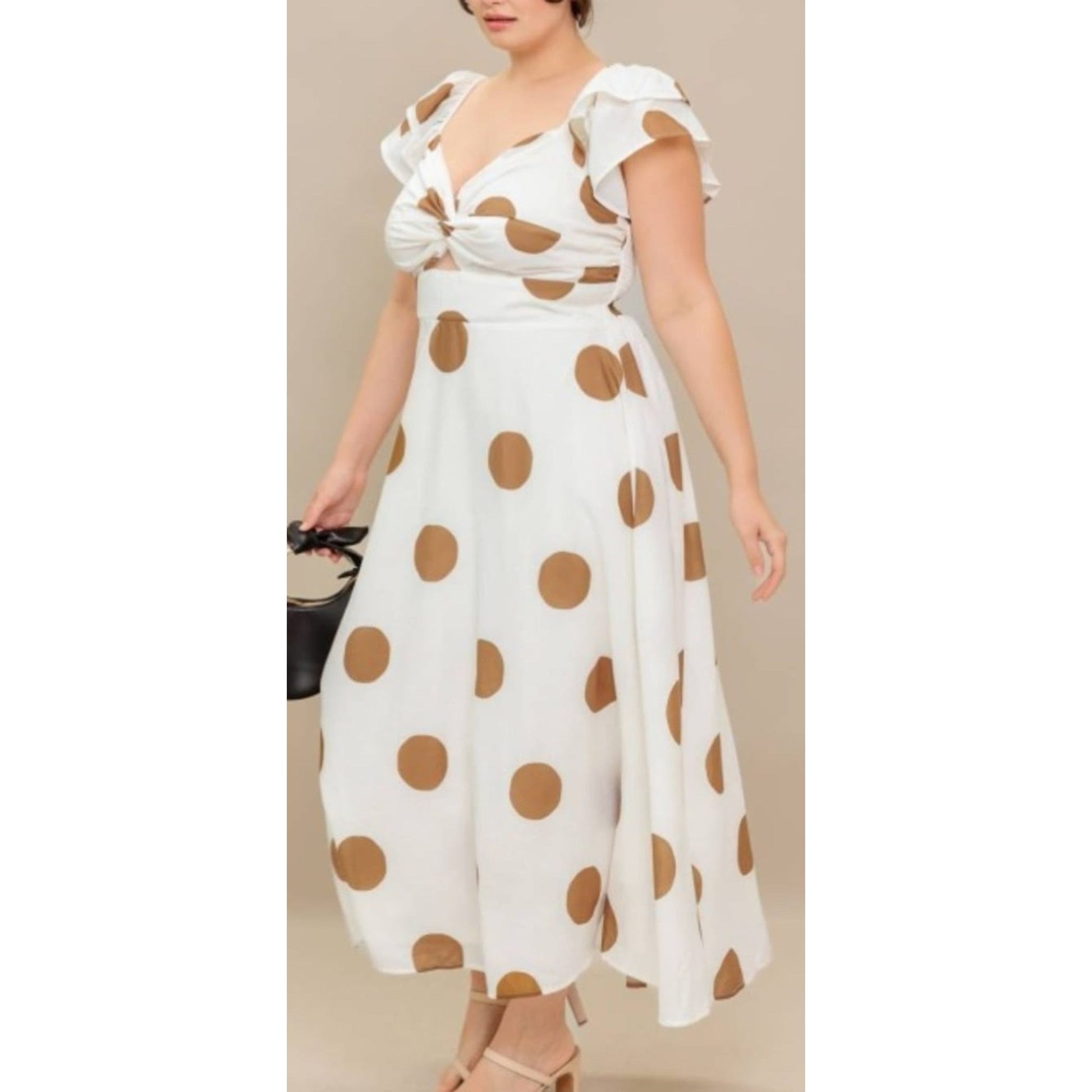 Woman wearing a white dress with brown polka dots against a beige background