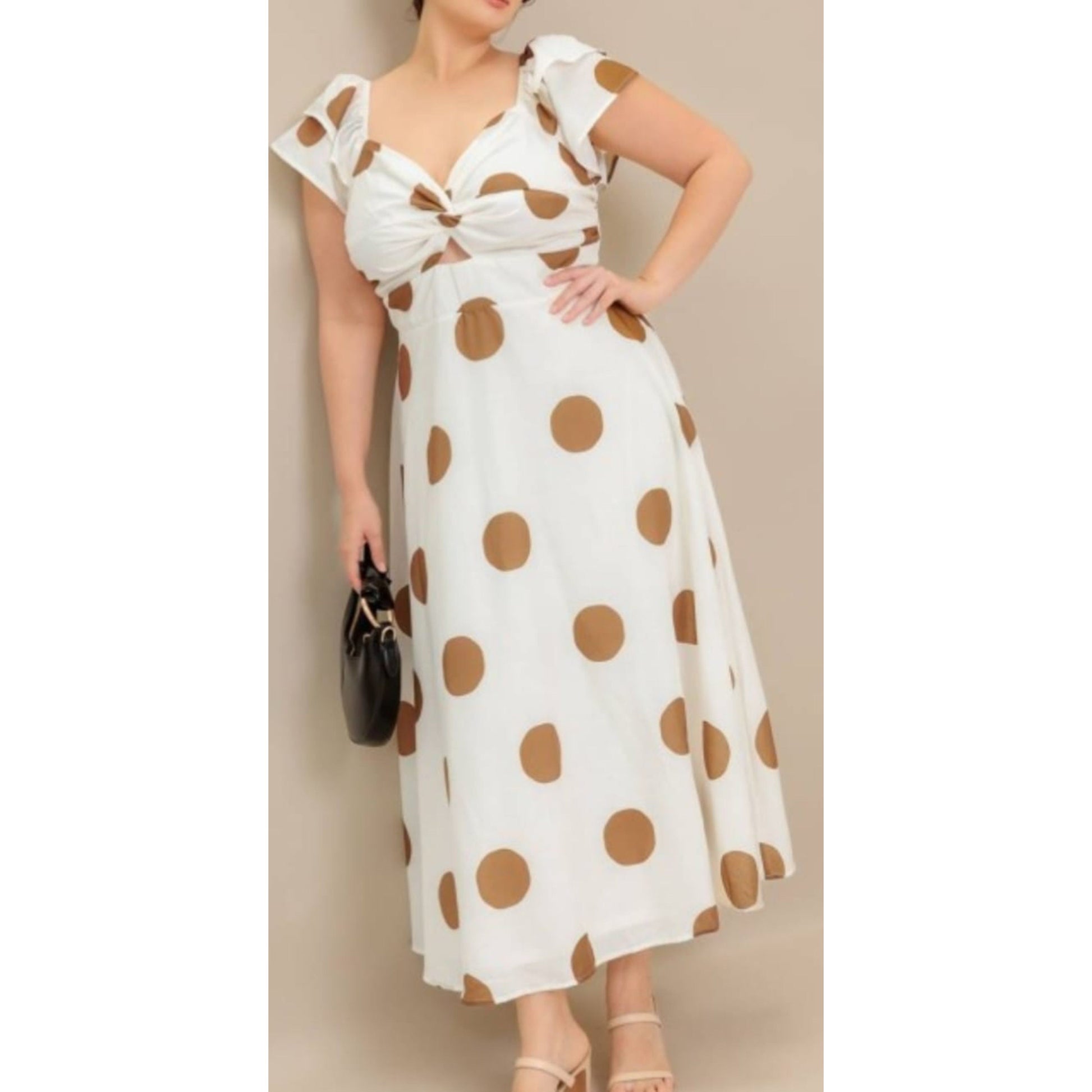 Woman wearing a white dress with brown polka dots against a beige background