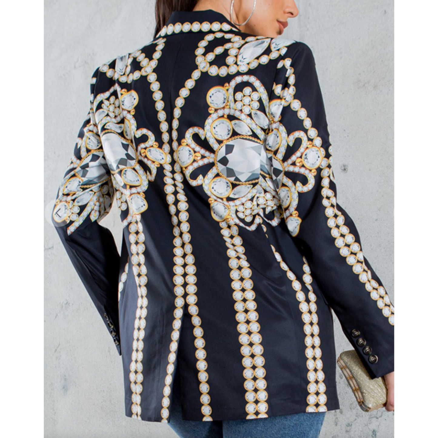Black blazer with intricate pearl and gemstone embellishments on a plain background