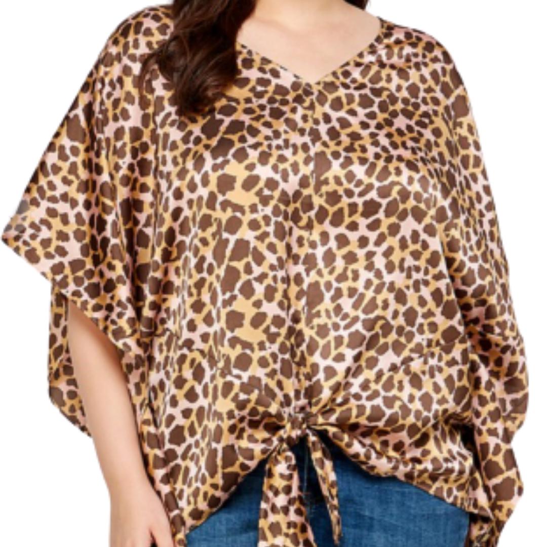 Woman wearing a pink and brown animal print loose top with a front tie, paired with jeans.